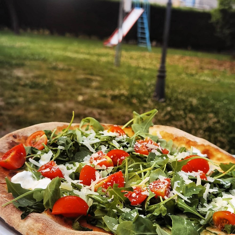 Pizza con bresaola, rucola, pomodorini e grana